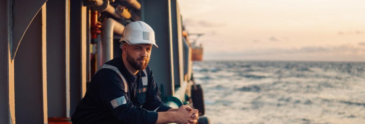 seafarer peers over water from ship