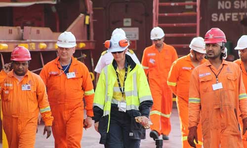 Group of seafarers in orange work gear with AMSA inspector in yellow 