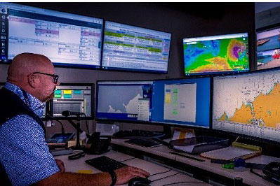 Control room for Tasmanian ports, seated figure surrounded by many digital screens