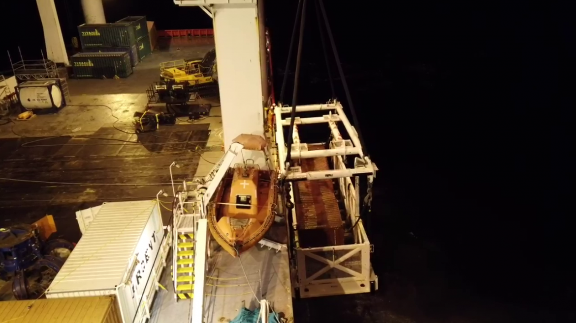 Basket with container being loaded onto the ship