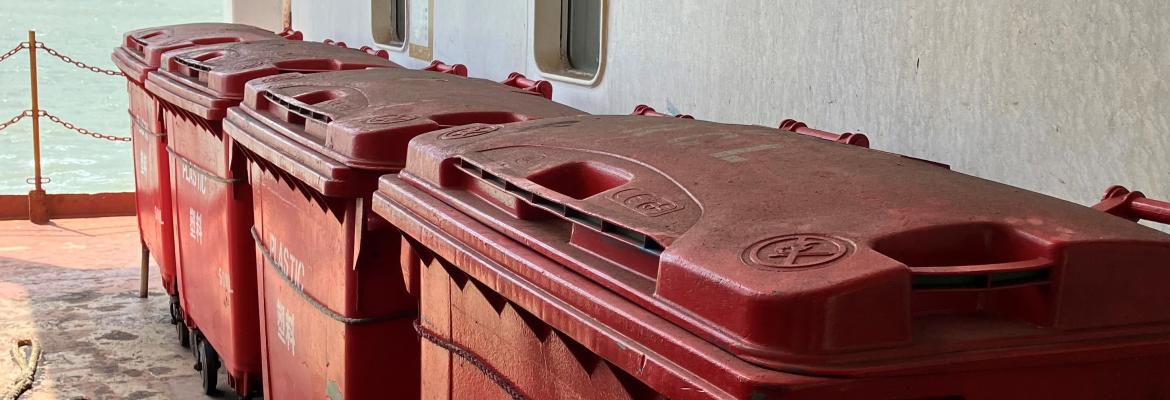 Large red recycling bins on board a vessel