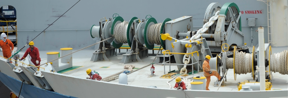 Seafarers on a vessel tying ropes onto a jetty