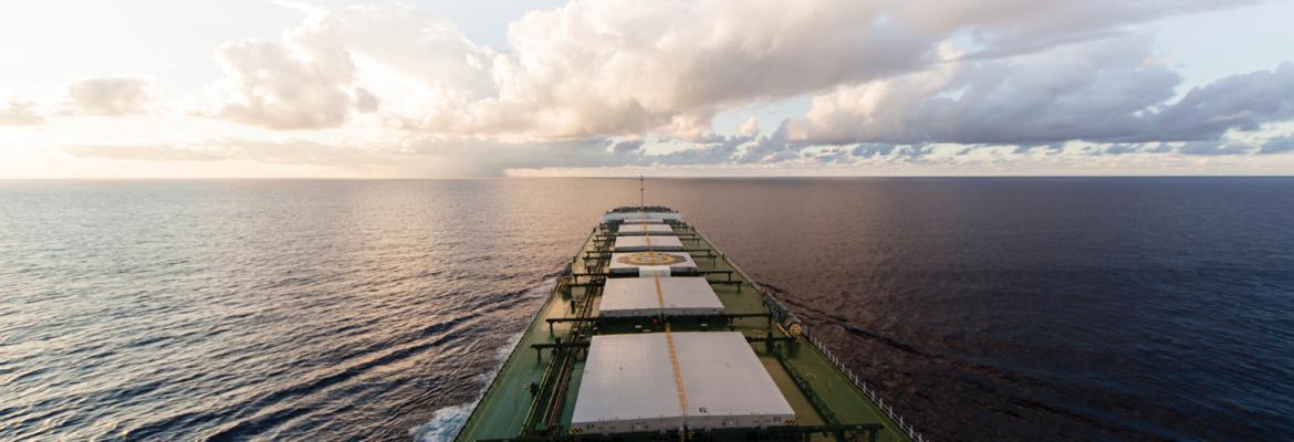 Cargo ship heading away towards the middle of the ocean