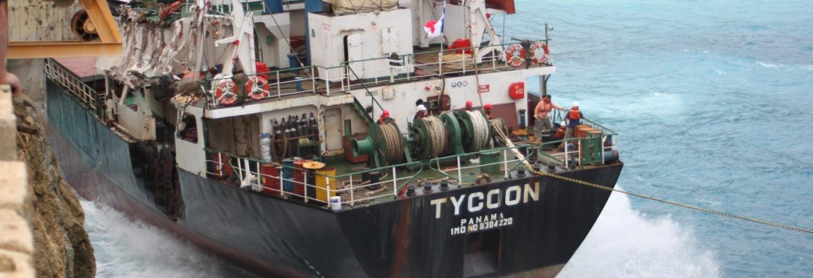 Image of MV Tycoon being washed against cliffs
