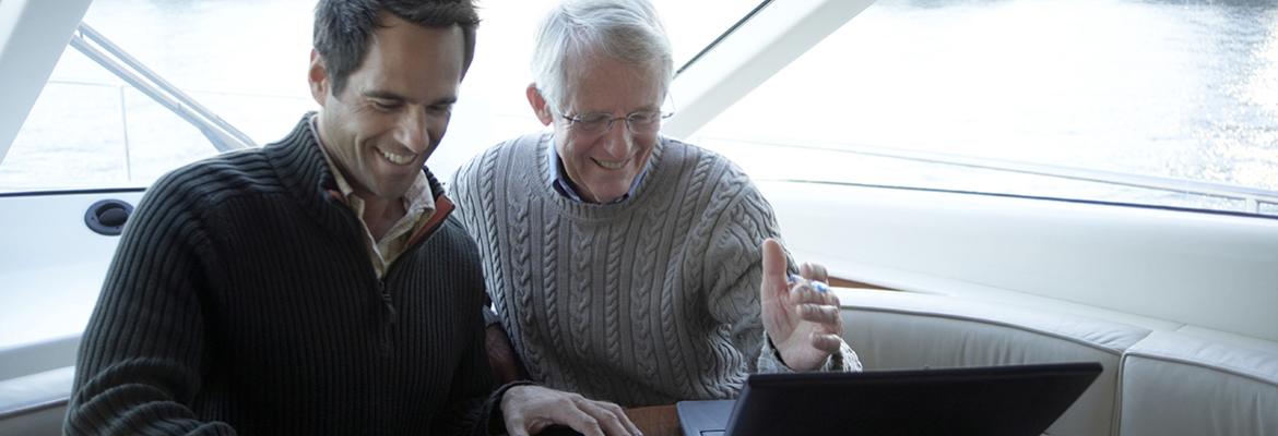 Two men on a vessel with laptop