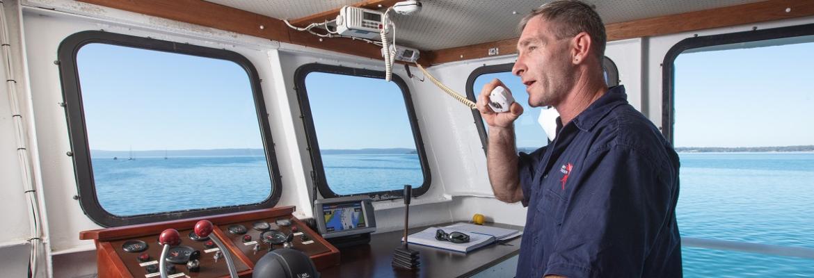 man speaking into a radio on a vessel
