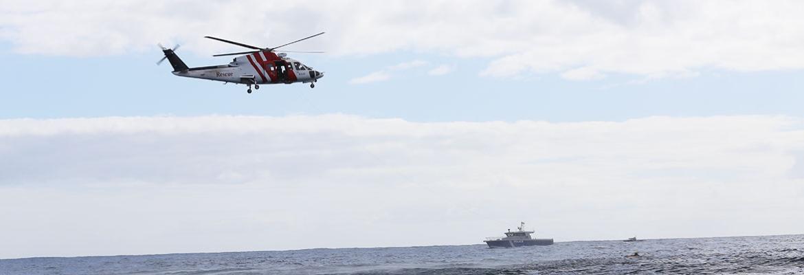 Helicopter in sky and vessel on water