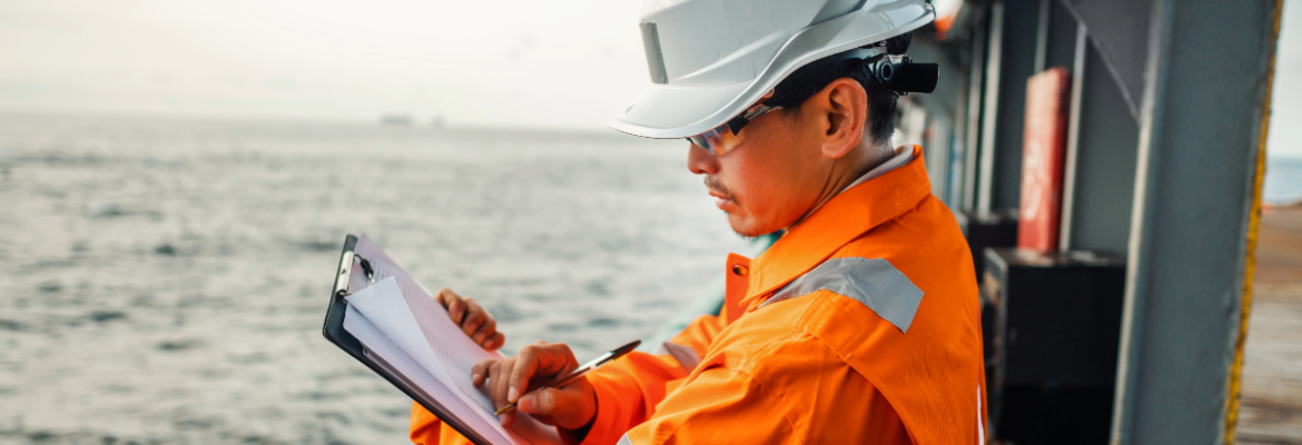 Image of a person wearing a hardhat and holding a clipboard